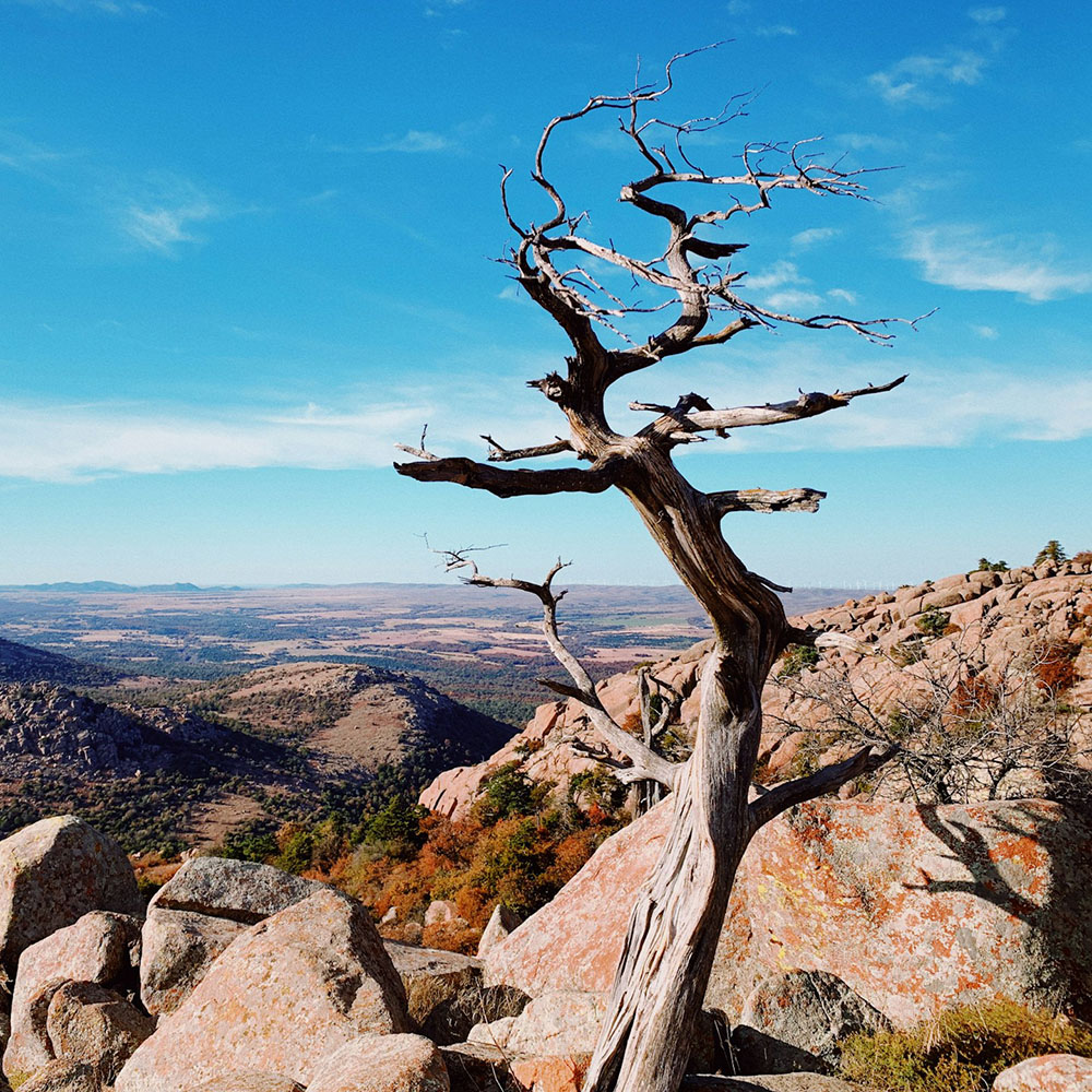 A breathtaking view from the top of Mount Scott in Oklahoma, overlooking expansive fields, farmland, and the rural countryside stretching to the horizon.