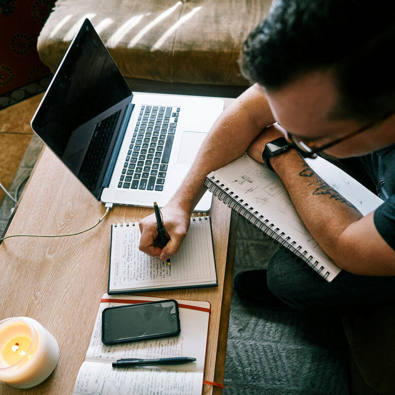 Nebraska Cannabis Consulting: Professional man sitting at a desk, filling out a Nebraska Cannabis Application for a License on his laptop.