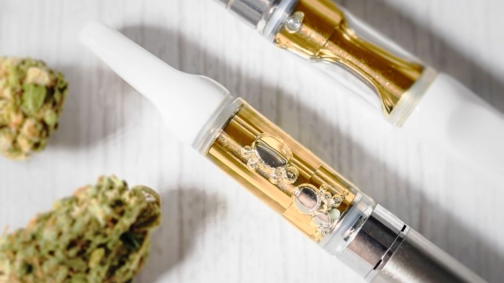 Tabletop display of cannabis flower and vape pens illustrating a Cannabis Product Strategy and Cannabis Unique Value Proposition