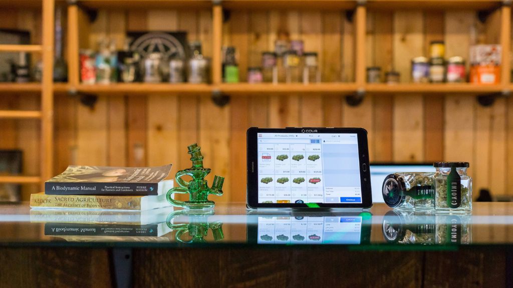 Retail Cannabis Dispensary counter with touchscreen display and cannabis products, illustrating Cannabis Business Strategy and Cannabis Consultant guidance