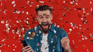 Man celebrating with phone in hand after winning a cannabis license in the Minnesota Lottery.