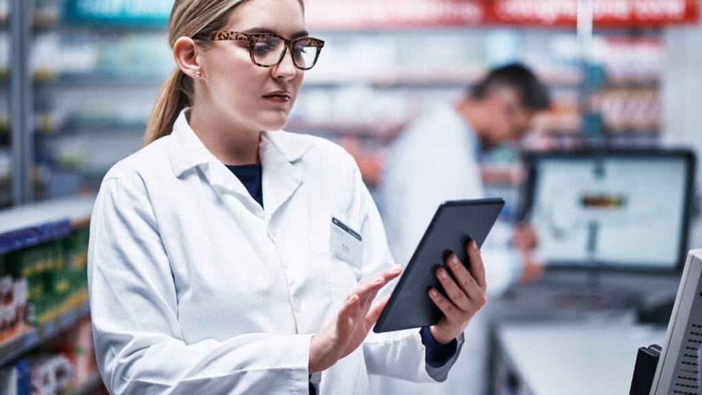 Nebraska Cannabis Dispensary License pharmacist reviewing cannabis inventory on a tablet to ensure compliance with Nebraska cannabis business application requirements.