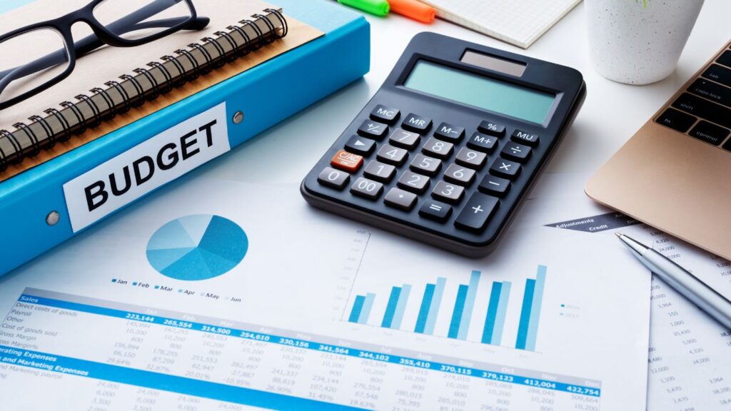 Close-up of financial planning documents, calculator, and budget book representing dispensary startup costs, cannabis licensing fees, and cannabis retail operations planning.