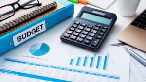 Close-up of financial planning documents, calculator, and budget book representing dispensary startup costs, cannabis licensing fees, and cannabis retail operations planning.