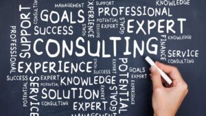 Close-up of a hand writing business terms like goals, consulting, professional, knowledge, and success on a chalkboard — representing a Canna Consultant developing a Cannabis Business Strategy focused on Cannabis Licensing and Cannabis Compliance.