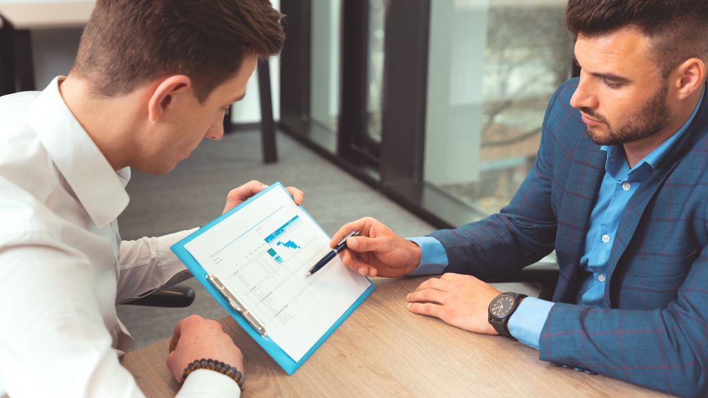 A cannabis consultant reviewing charts and financial data with a client during a strategy session.